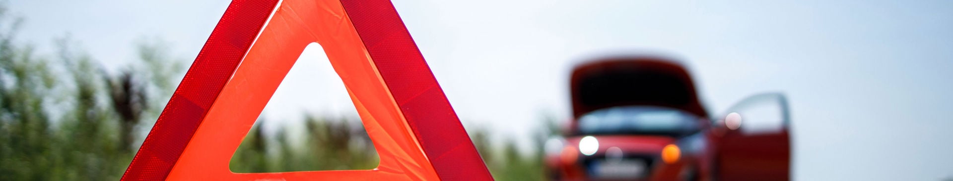 närbild på varningstriangel framför en bil